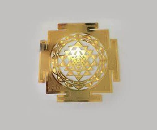 A gold colored metal object with the symbol for sri yantra in it.